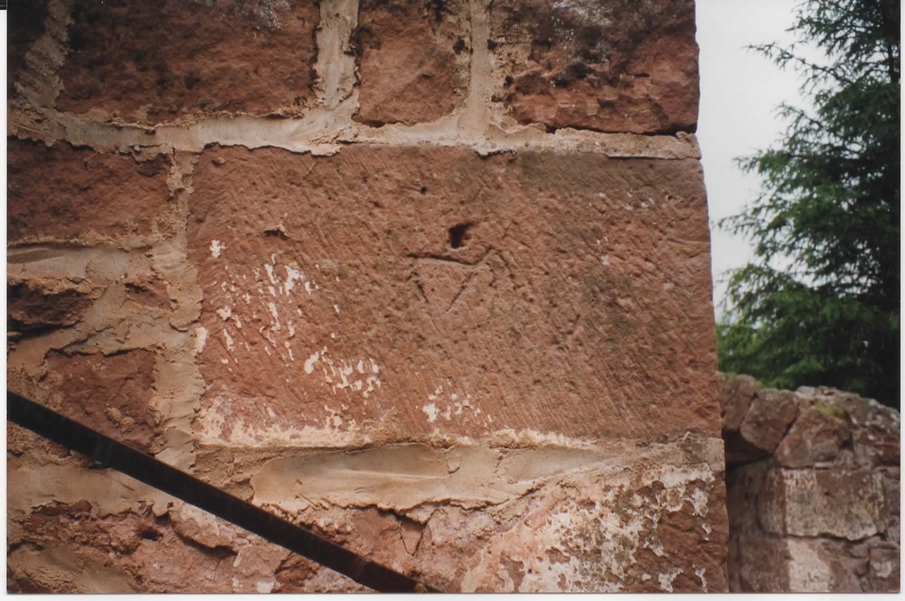 Marque de maçon sur une pierre d'angle du donjon