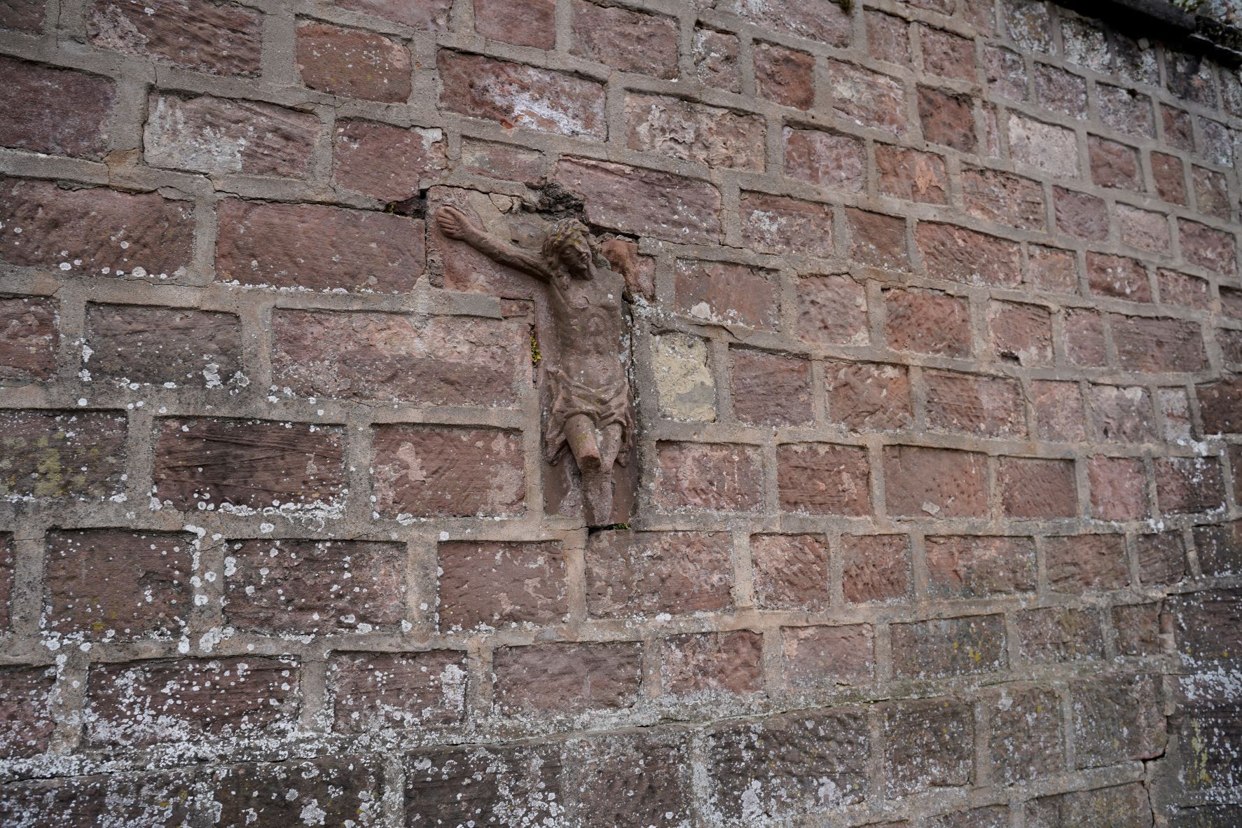 Haut-relief en grès de 1792 représentant le Christ en croix sur le mur du cimetière